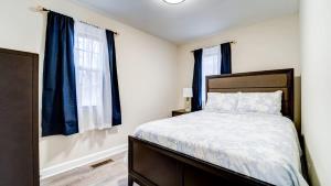 a bedroom with a bed with blue curtains at Family Retreat Near Yale - Stylish Free Wifi in New Haven
