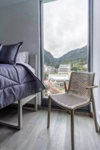 a bedroom with a bed and a chair and a window at Cozy and centrally located flat near Monserrate - 11005 in Bogotá