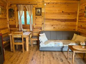 a bedroom with a bed and a table in a log cabin at Drveni raj Uvac in Sjenica