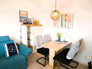 a living room with a table and a blue couch at Residenz Seestern Ws 08 in Kühlungsborn