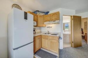 a kitchen with wooden cabinets and a white refrigerator at Assateague Inn 208-S in Deep Hole