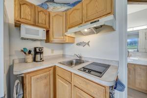 a small kitchen with wooden cabinets and a sink at Assateague Inn 208-S in Deep Hole