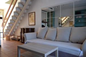 ein Wohnzimmer mit weißem Sofa und Treppe in der Unterkunft Casa 712 in Caleri + 7 Fotos