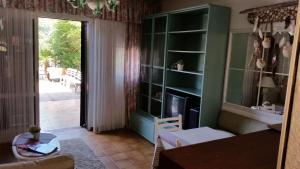 ein Wohnzimmer mit einem grünen Bücherregal und einem Tisch in der Unterkunft Casa 712 in Caleri