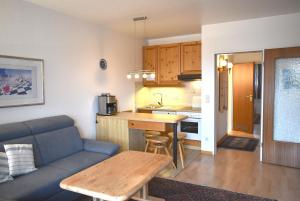 a living room with a couch and a kitchen at Sonnenseite Ferienwohnung in Niendorf