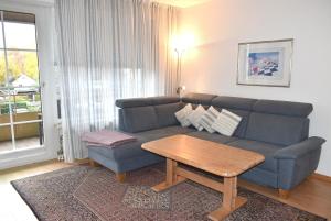 a living room with a blue couch and a coffee table at Sonnenseite Ferienwohnung in Niendorf