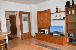 a living room with a television on a wooden table at Sonnenseite Ferienwohnung in Niendorf +17 photos