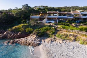 an aerial view of a house on a cliff next to the ocean at Princes Apartment PortoCervoBEACH con accesso diretto in spiaggia Piccolo Pevero in Porto Cervo