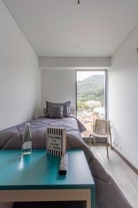 a bedroom with a bed and a table with a book at Cozy and centrally located flat near Monserrate - 11009 in Bogotá +24 photos