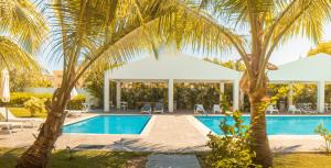 a villa with a swimming pool and palm trees at 3 Min Walk to Bibijagua Beach - Spacious 2BR in Punta Cana