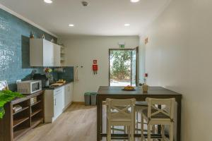 a kitchen with a table and chairs in a room at Fly House Faro in Faro