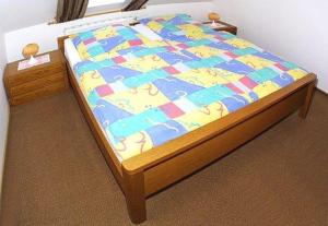 a bedroom with a bed with a colorful bedspread on it at Landhaus Schwanenhof in Ostbense in Westbense