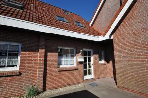 a brick house with a red roof at Nr 26 - Ferienhaus Bootsweg in Harlesiel