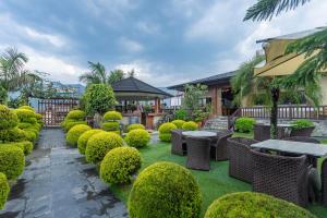 a garden with tables and chairs and bushes at The Culture Resort in Pokhara