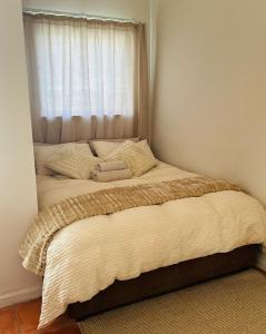 una cama en una habitación con ventana en Niizala Apartments, en Windhoek