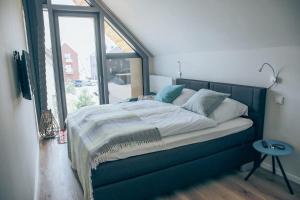 a bed in a room with a large window at Villa Dünengras, 4GW16A in Heiligenhafen