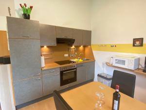 a kitchen with stainless steel appliances and a table with a bottle of wine at Ferienhaus Seepferdchen in Sehestedt +6 photos