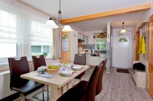 a kitchen and dining room with a table and chairs at Trassenheide, Ferienhaus Teuber I in Trassenheide