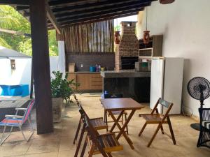 a kitchen with a table and chairs and a refrigerator at Chale Praia Barrinha in Barrinha