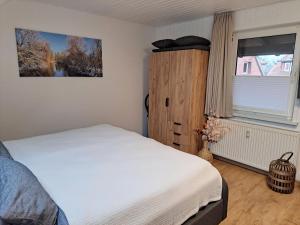 a bedroom with a white bed and a window at Ferienwohnungen Zur alten Dachdeckerei in Bad Bevensen