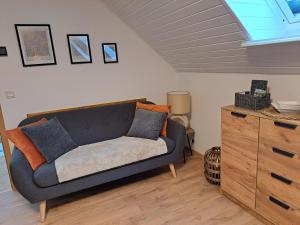 a living room with a blue couch and a dresser at Ferienwohnungen Zur alten Dachdeckerei in Bad Bevensen