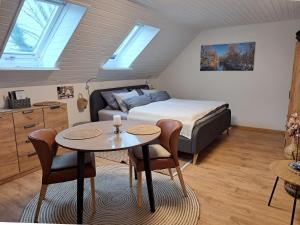 a bedroom with a bed and a table and a bed at Ferienwohnungen Zur alten Dachdeckerei in Bad Bevensen