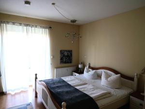 una camera da letto con un letto con lenzuola bianche e una finestra di Residenz Strandkrone 03 a Kühlungsborn