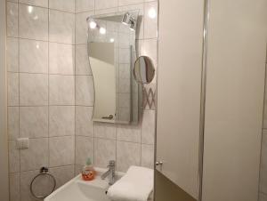 un bagno con lavandino e doccia con specchio di Residenz Strandkrone 03 a Kühlungsborn Altre 3 foto