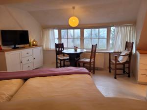 a bedroom with a bed and a table and chairs at Apartment Atelierhaus Wencke in Worpswede