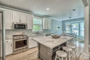 kuchnia z białymi szafkami oraz duża wyspa z barowymi stołkami w obiekcie For A Song by 30A Escapes w mieście Rosemary Beach +29 zdjęć