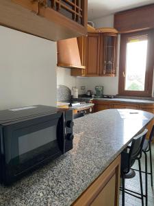 a kitchen with a counter top with a black microwave at Milan Suburban Escape -Family Apartment in Arcore +6 photos