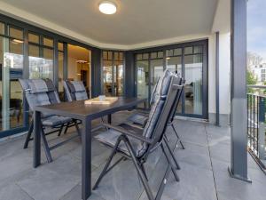 a wooden table and chairs on a patio at Villa Beatrice - Wohnung 01 in Binz +31 photos