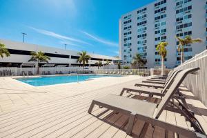 a row of lounge chairs sitting next to a swimming pool at Landing Apartments - St Petersburg in St Petersburg