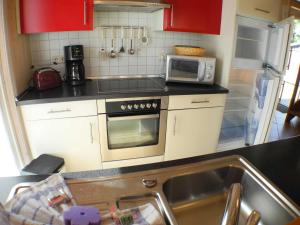 a small kitchen with a stove and a microwave at Ferienhaus Sonnenblume in Baabe in Baabe +11 photos