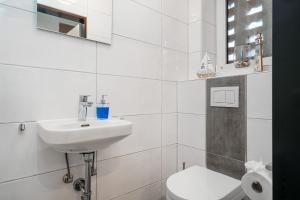 une salle de bain blanche avec un lavabo et des toilettes dans l'établissement Von Manderley, Ferienhaus mit 3 Schlafzimmern und Garten, Hund willkommen!, à Greetsiel 15 autres photos