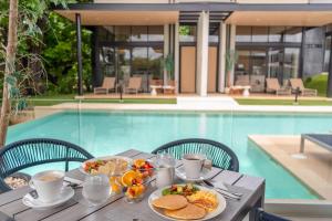 a table with food on it next to a pool at Epic Tamarindo Boutique Hotel in Tamarindo