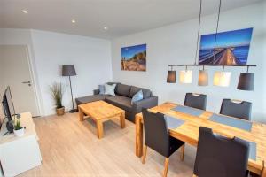ein Wohnzimmer mit Tisch und Couch in der Unterkunft Ferienpark - Haus C, App 0C1109 in Heiligenhafen