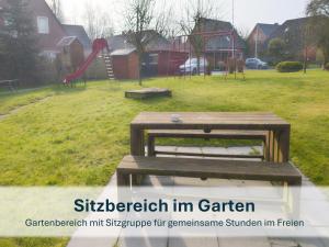 a park with a wooden bench and a playground at Stedesdorf, Ferienhaus 'Seehund' in Stedesdorf
