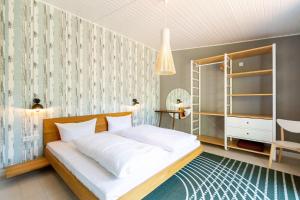 Un dormitorio con una gran cama blanca y un estante en Haus Silvana, App 03 Bungalow, en Zempin