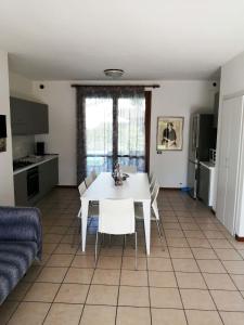 a kitchen and living room with a white table and chairs at Olivelli 1 in Palazzo Vianello