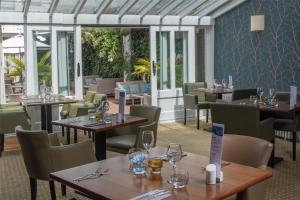 a restaurant with tables and chairs with wine glasses at Best Western Ship Hotel in Weybridge