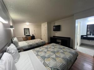a hotel room with two beds and a television at Studio 6 Suites Euless, TX – DFW West in Euless