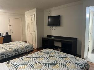 a bedroom with two beds and a tv on the wall at Studio 6 Suites Euless, TX – DFW West in Euless +60 photos