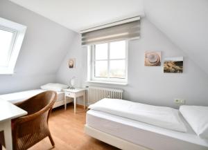 Un dormitorio con dos camas y una ventana. en Haus Windhuug Wohnung 5, en Utersum 2 fotos más