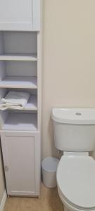 a white bathroom with a white toilet in a room at Gem Relax in Leighton Buzzard +42 photos