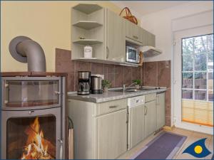 アールベックにあるHaus Kieferndüne Bungalow rechtsのキッチン(コンロ、暖炉付)