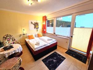 アールベックにあるHaus Kieferndüne Bungalow rechtsのベッドとテーブルと窓のある寝室 +6枚の写真