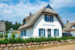 a white building with a thatched roof at Dünenbraut in Glowe