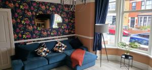 ein Wohnzimmer mit einem blauen Sofa und einem Spiegel in der Unterkunft Stunning Spacious Home Close to Blackpool Beach in Blackpool