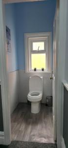 ein Bad mit einem weißen WC und einem Fenster in der Unterkunft Stunning Spacious Home Close to Blackpool Beach in Blackpool